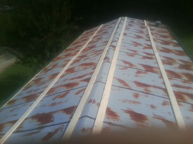 Rusted metal roof panels with new wood purlins before replacement — Storm Damage Roof Repair in Hudson by Roofing Brothers